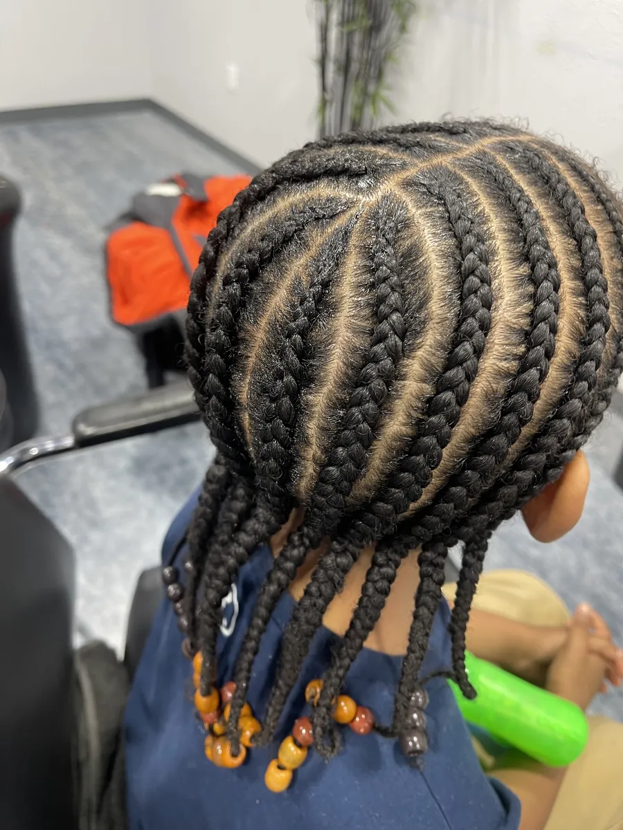 Child's cornrows finished with orange beads