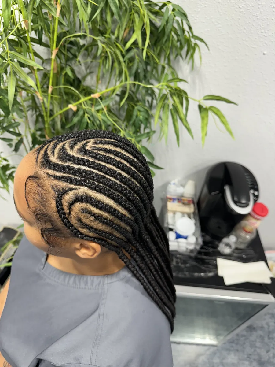 Child's curved cornrows, side view