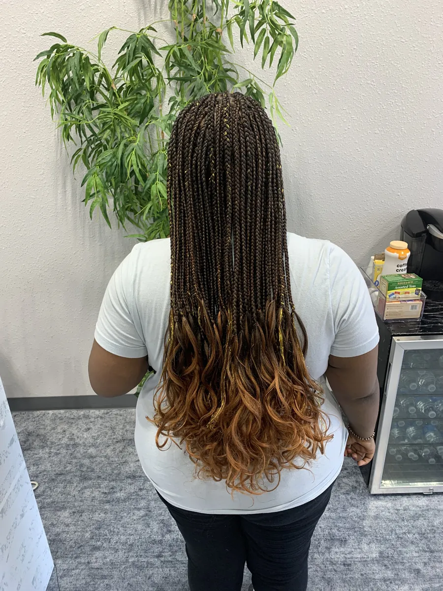 Knotless braids in dark brown fading to copper curly ends
