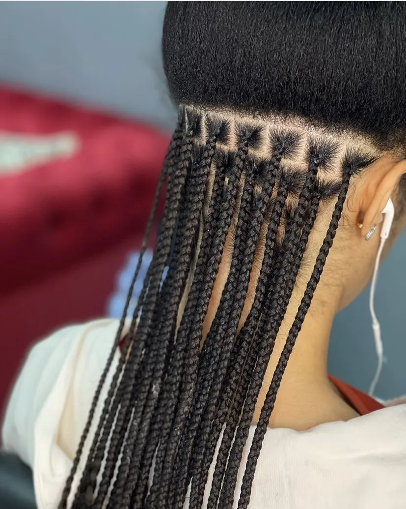 Small black knotless braids with neat square parts at the nape